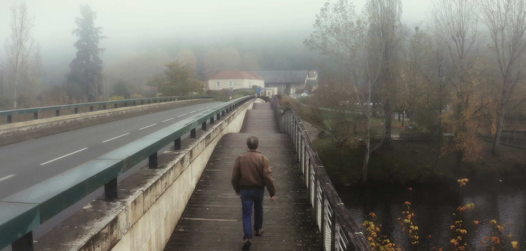 Alan Lightman walking on a bridge